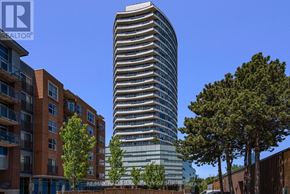 Ottawa condo for rent - A tall glass building stands in front of a row of smaller buildings.
