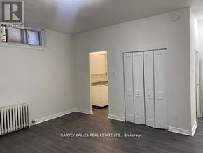 Toronto (Humewood-Cedarvale) condo for rent - A room with a white wall and a wooden floor with a cabinet and a drawer.