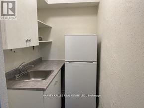 Toronto (Humewood-Cedarvale) condo for rent - A small kitchen with a sink and a refrigerator.
