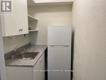 Toronto (Humewood-Cedarvale) condo for rent - A small kitchen with a sink and a refrigerator.