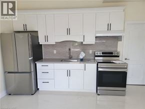 Brantford apartment for rent - A kitchen with white cabinets and a stainless steel refrigerator.
