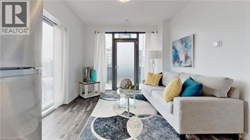Kitchener condo for rent - A living room with a grey couch and a rug.