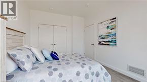 Kitchener condo for rent - A bedroom with a bed, pillows, and a painting on the wall.