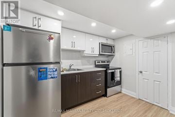 St. Catharines (E. Chester) apartment for rent - A kitchen with a stainless steel refrigerator and wooden floors.