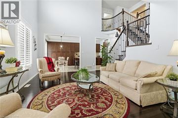 Hamilton apartment for rent - A living room with a rug, a couch, a chair, a table and a staircase.