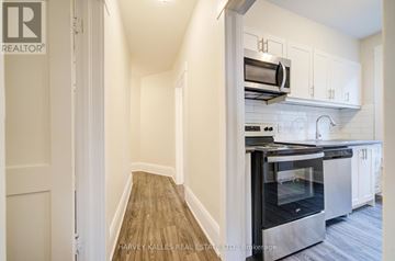 Toronto (Oakwood Village) multi-family for rent - A kitchen with a stainless steel oven and white cabinets.