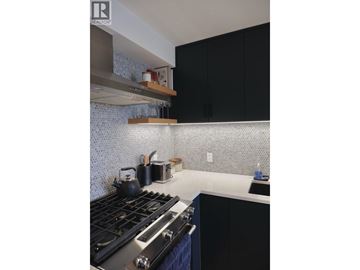 North Vancouver apartment for rent - A kitchen with a stove top oven and black cabinets.