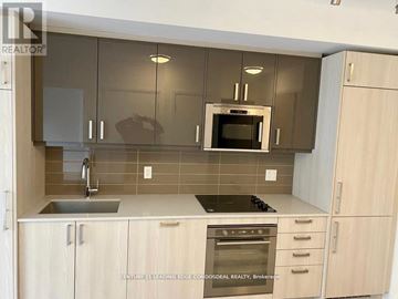 Toronto (Church-Yonge Corridor) condo for rent - A kitchen with wooden cabinets and a stainless steel oven.
