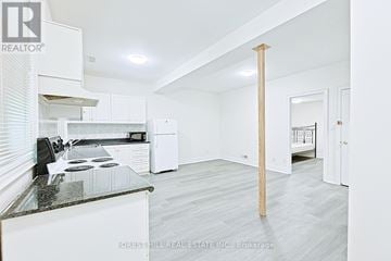 Toronto (Newtonbrook West) apartment for rent - A kitchen with white cabinets and a black countertop.