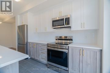 Ottawa townhouse for rent - A modern kitchen with white cabinets and stainless steel appliances.