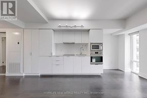Toronto (Bay Street Corridor) condo for rent - A modern kitchen with white cabinets and appliances.