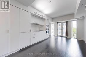 Toronto (Bay Street Corridor) condo for rent - A spacious kitchen with white cabinets and a black floor.
