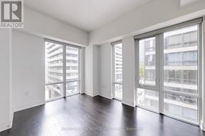 Toronto (Bay Street Corridor) condo for rent - A spacious room with large windows and wooden floors.