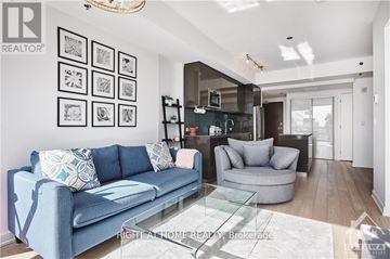 Ottawa condo for rent - A living room with a blue couch and a glass coffee table.