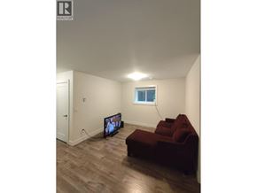 New Westminster apartment for rent - A living room with a red couch and a television.