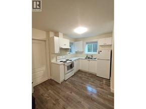 New Westminster apartment for rent - A kitchen with white cabinets and a wooden floor.