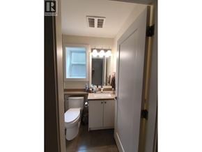 New Westminster apartment for rent - A bathroom with a toilet, sink, and mirror.