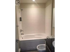 Vancouver apartment for rent - A white toilet sits next to a bathtub in a bathroom.