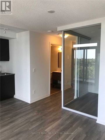 Toronto (Woburn) condo for rent - A modern living room with a television and a glass door leading to a balcony.