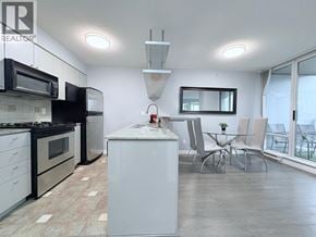 Vancouver apartment for rent - A kitchen with black and white appliances and a white island.