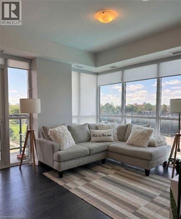 Kitchener condo for rent - A living room with a grey couch and a large window.
