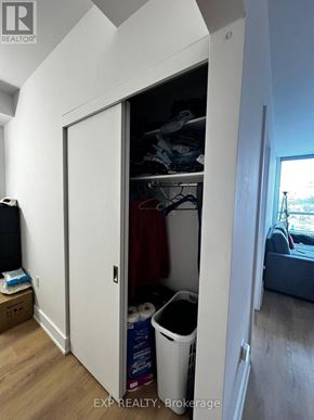 Ottawa condo for rent - A white closet with a door open showing clothes and a trash can.