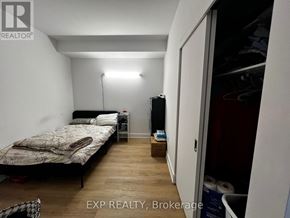 Ottawa condo for rent - A bedroom with a bed, nightstand, and a lamp.