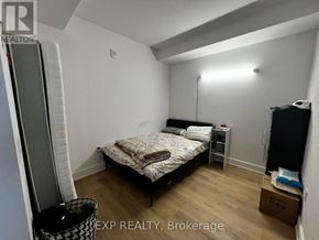 Ottawa condo for rent - A bedroom with a bed, nightstand, and a trash can.