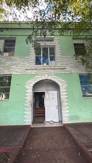 Miami apartment for rent - A green building with a white door and a window.