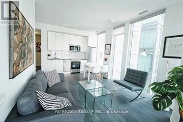 Toronto (Church-Yonge Corridor) condo for rent - A modern living room with a grey couch, a glass coffee table, and a large painting on the wall.