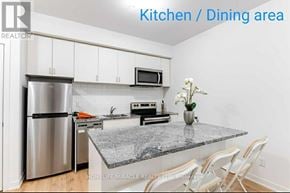 Oshawa (Samac) townhouse for rent - A kitchen with a granite countertop and white cabinets.