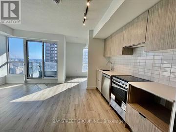 Toronto (North St. James Town) condo for rent - A kitchen with a stove top oven and a dishwasher.