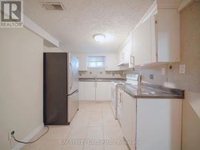 Brampton (Downtown Brampton) apartment for rent - A kitchen with white cabinets and a black refrigerator.