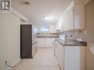 Brampton (Downtown Brampton) apartment for rent - A kitchen with white cabinets and a black refrigerator.