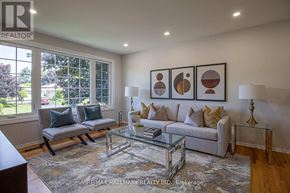 Newmarket (Gorham-College Manor) apartment for rent - A living room with a grey couch, a glass coffee table, and a large window.