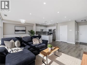 Mississauga condo for rent - A living room with a dark blue sofa and a wooden coffee table.