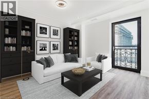 Hamilton condo for rent - A living room with a white couch, a coffee table, and a bookshelf.