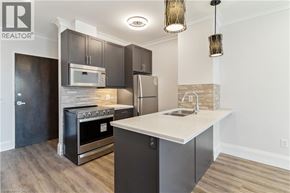 Hamilton condo for rent - A modern kitchen with dark wood cabinets and stainless steel appliances.