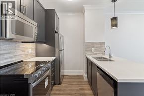 Hamilton condo for rent - A modern kitchen with a stove top oven and a refrigerator.