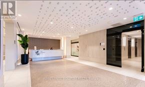 Toronto (Humewood-Cedarvale) condo for rent - A reception area with a white reception desk and a plant in a black pot.
