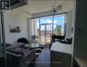 Toronto (Humewood-Cedarvale) condo for rent - A living room with a grey couch and a table in front of a large window.