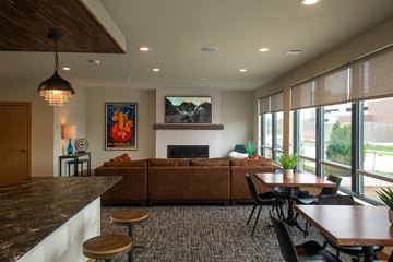 Greenfield apartment for rent - A modern living room with a fireplace and a painting of a sunset.