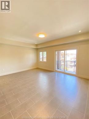 Windsor condo for rent - A spacious room with tile flooring and a large window.