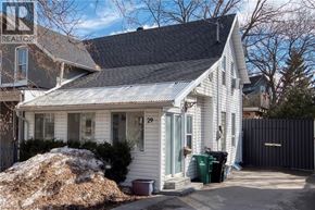 Kitchener apartment for rent - A white house with a black roof and a sign that says REALTOR.