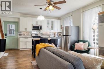 Kitchener apartment for rent - A living room with a grey couch and a ceiling fan.