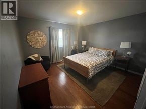 Chatham apartment for rent - A bedroom with a bed, nightstand, and chair.