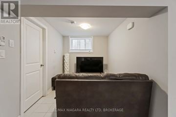 Welland (Welland Downtown) apartment for rent - A living room with a brown couch and a fireplace.