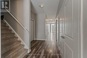 Welland (Welland Downtown) apartment for rent - A hallway with a staircase on the left and doors on the right.