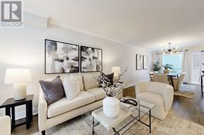Pickering (Highbush) apartment for rent - A living room with a white couch, a glass coffee table, and a painting on the wall.