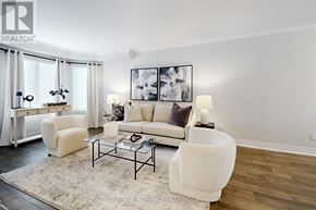 Pickering (Highbush) apartment for rent - A living room with a white couch, a glass coffee table, and a large painting on the wall.